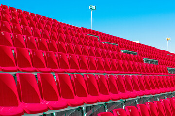 Rows of empty red color plastic stadium seating on the terrace