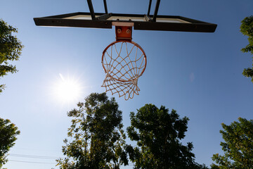 Basketball hoop with blue sky with low angle view - Powered by Adobe