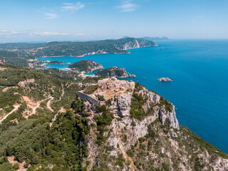 Aerial drone view of famous iconic medieval fortified castle of Aggelokastro with amazing views to Paleokastritsa bay, Corfu Greece