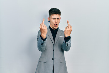 Young caucasian boy with ears dilation wearing business jacket showing middle finger doing fuck you...