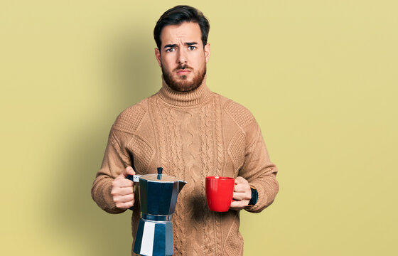 Young hispanic man drinking italian coffee skeptic and nervous, frowning upset because of problem. negative person. - Powered by Adobe