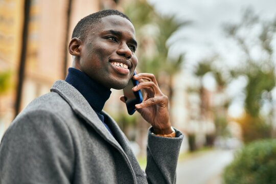 Young african american man smiling happy talking on the smartphone at the city