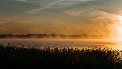 Nebelschwaden über dem Bodden an der Ostsee im Morgengrauen