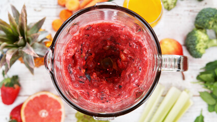 Mixing pieces of fruits in blender, top view.