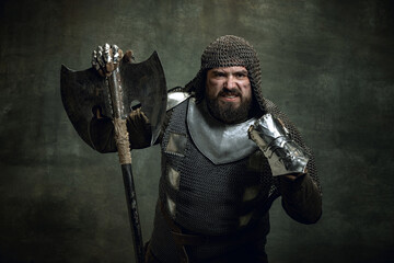 Vintage portrait of brutal seriuos man, medieval warrior or knight with wounded face in chain mail...