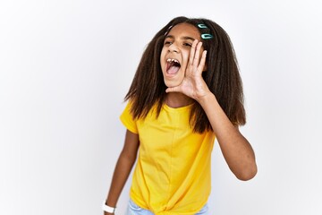Young african american girl standing over white isolated background shouting and screaming loud to...