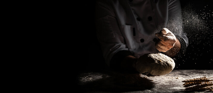 White flour flying into air as pastry chef in white suit slams ball dough on white powder covered table. concept of nature, Italy, food, diet and bio