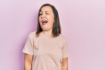 Fototapeta premium Middle age hispanic woman wearing casual clothes winking looking at the camera with sexy expression, cheerful and happy face.