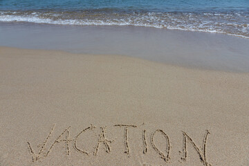 Handwritting inscription Vacation word on tropical sandy beach, travel concept card for holidays