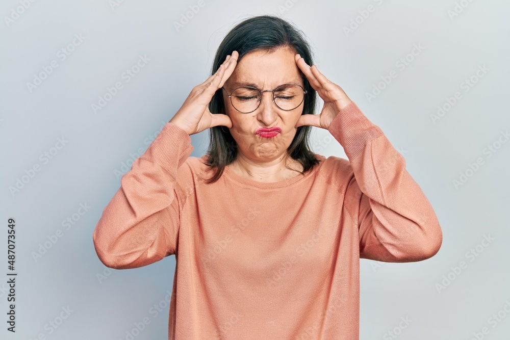 Canvas Prints Middle age hispanic woman wearing casual clothes and glasses suffering from headache desperate and stressed because pain and migraine. hands on head.