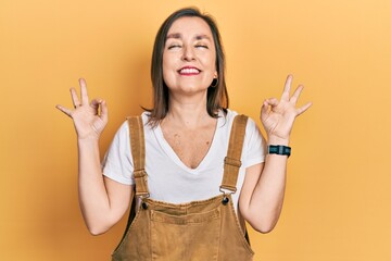 Middle age hispanic woman wearing casual clothes relax and smiling with eyes closed doing meditation gesture with fingers. yoga concept.