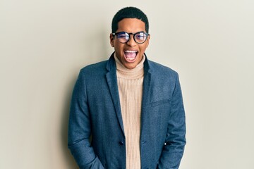 Young handsome hispanic man wearing elegant clothes and glasses winking looking at the camera with...