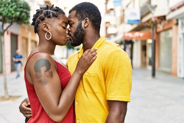 Young afircan american couple hugging and kissing standing at the city.