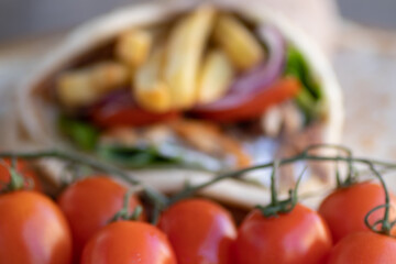 Greek Gyros street food for take away, nicely wrapped with tomato, souvlaki, Greek salad, onion and French fries  
