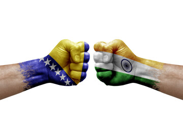 Two hands punch to each others on white background. Country flags painted fists, conflict crisis concept between bosnia and india
