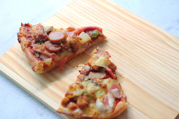 2 pizzas served on a white wooden tray.