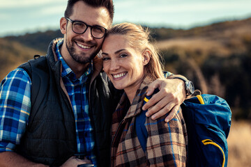Portrait of adult couple hiking in nature at sunset.