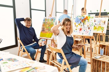 Group of middle age artist at art studio crazy and scared with hands on head, afraid and surprised of shock with open mouth