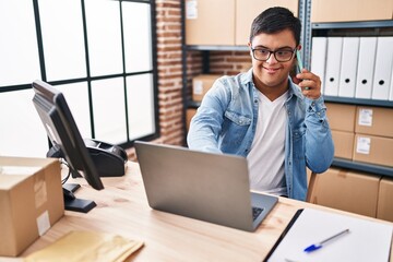 Down syndrome man ecommerce business worker talking on the smartphone at office