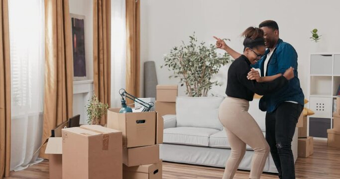 A couple in love moves into a new apartment, the removal of all the cardboard boxes, a new chapter in life, buying, renting a house, the boy along with the girl dance with joy