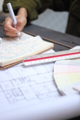 Hands of Asian female engineers are working on construction drawings on site.