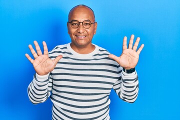 Middle age latin man wearing casual clothes and glasses showing and pointing up with fingers number ten while smiling confident and happy.