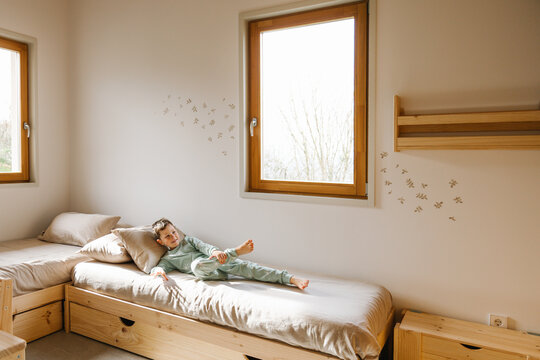 Cheerful boy lying on bed
