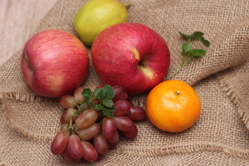 Fruits with vitamin C that are beneficial to the body. Place on sackcloth - orange, grape, apple, guava