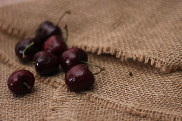 purple cherries placed on a cloth sack