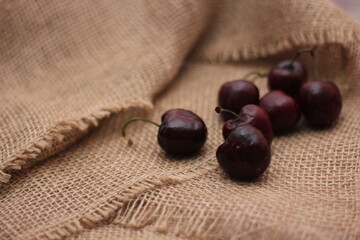 purple cherries placed on a cloth sack