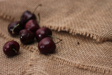 purple cherries placed on a cloth sack