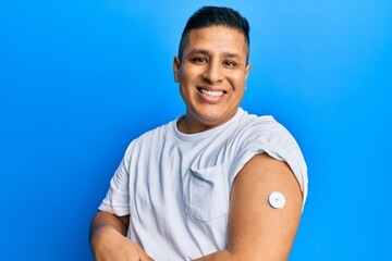 Hispanic man showing diabetes device on arm