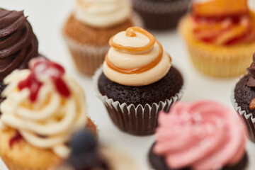 Kleiner Cupcake mit Topping aus Karamell und Creme