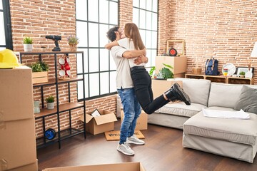 Man and woman couple smiling confident hugging each other at new home