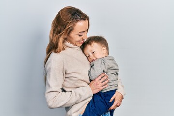 Young caucasian woman holding and hugging her son with love. Family of two bonding together. Mother holding infant toddler