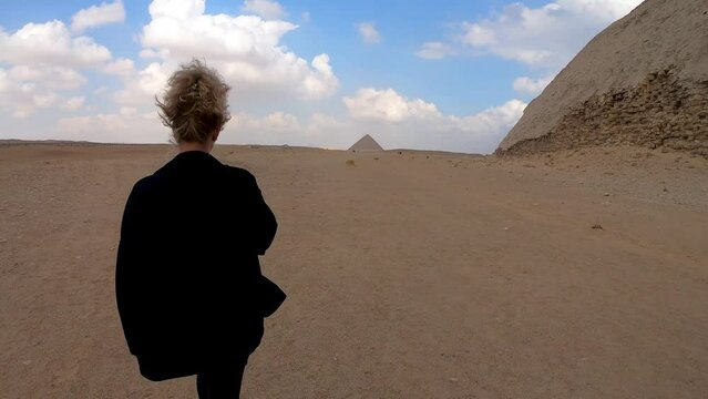 A Woman walking near the Bent Pyramid in Egypt.