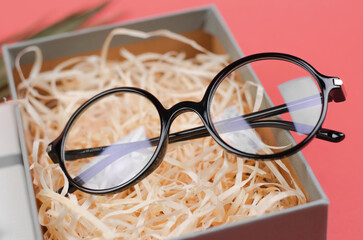 Stylish round glasses in a gift box. Close-up eyeglasses, selective focus