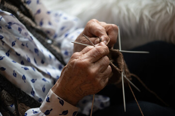 Close up of the hands of an elderly woman knitting sock