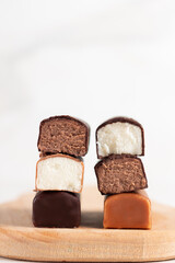 Glazed curds in chocolate on a wooden board. Different dessert with glazed cheese.