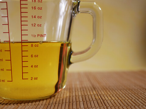 Measuring glass jug with vegetable oil close up shot