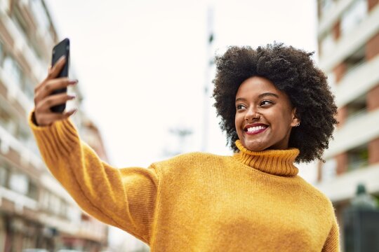 Young african american girl smiling happy making selfie by the smartphone at the city.