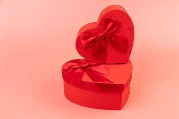 Red box in shape of heart. Gift box for Valentine's Day. Isolated on pink background.