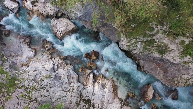 Aerial View Above The Surface Of A Mountain River Soca , stream flowing through rocky canyon. River stones with flowing water, clean water flowing in a mountain river