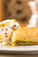 Traditional Turkish dessert pistachio baklava on a white porcelain plate
