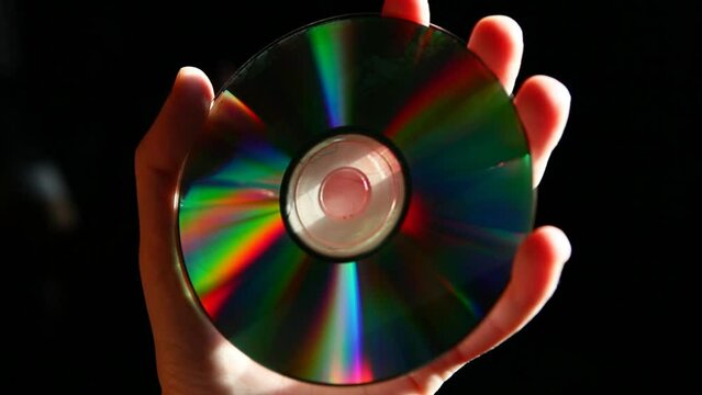 footage of cd disk hand dark background
