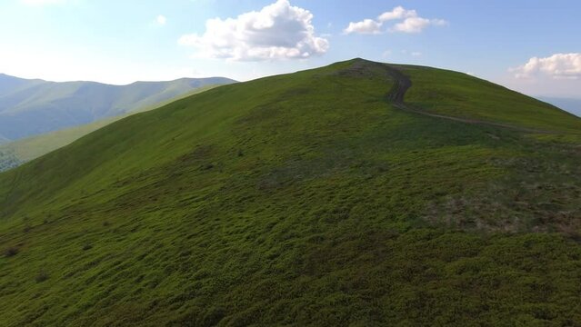 Aerial flight over green hill mountains. FPV Dynamic drone shot