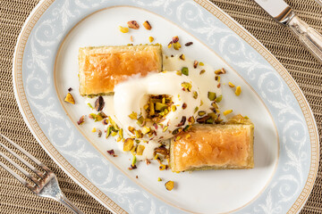 Traditional Turkish dessert pistachio baklava on a white porcelain plate