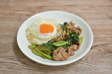 spicy stir fried Chinese kale with pork topping egg on rice