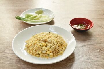 fried rice crab meat and egg with slice cucumber couple lemon on plate
