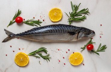 Fresh fish with lemon, rosemary, salt and pink pepper on wooden board and parchment. 